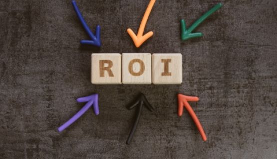 Wooden block letters spelling out R O I, with colourful arrows pointing to them